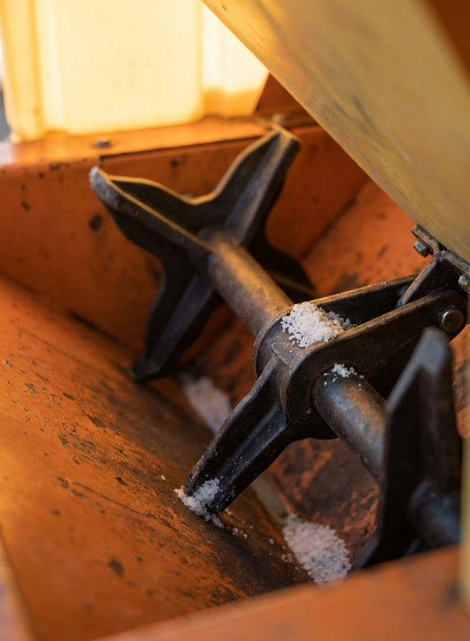 Close-up of snow removal equipment with blades and traces of snow
